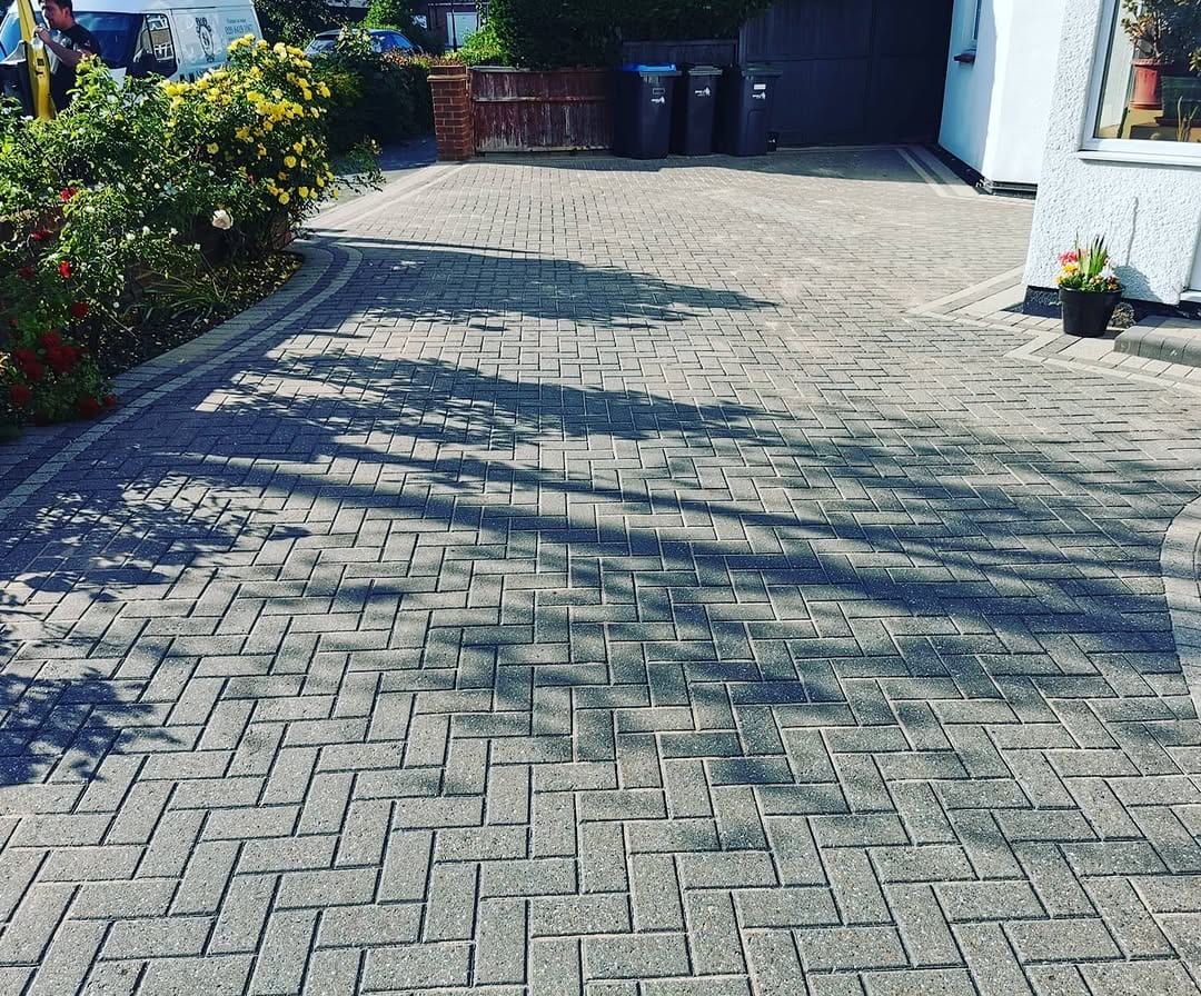 A cleaned herringbone block-paved driveway, with the edge of the Aspen Rose van visible