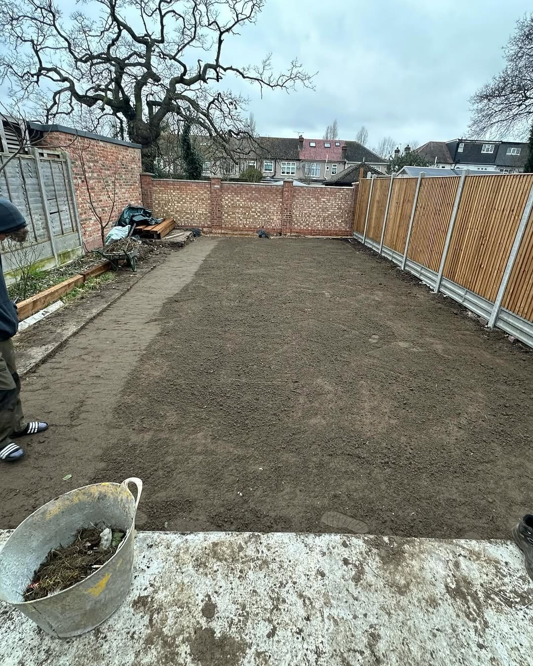 An Aspen Rose gardener preparing a London garden bed for new turf